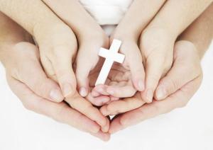 Generational hands holding cross